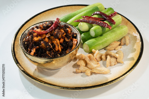 Pork Crackling Chili Paste (Nam Phrik kak Moo): Crispy, spicy, and savory. This Thai relish features crunchy cracklings, chili, and herbs. Served with fresh cucumber. A perfect crunch with hot rice.