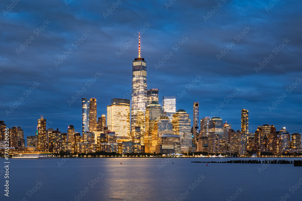 Obraz premium Twilight view of Lower Manhattan skyline with World Trade Center illuminated skyscrapers. Scenic New York City waterfront and Financial District at dusk, USA