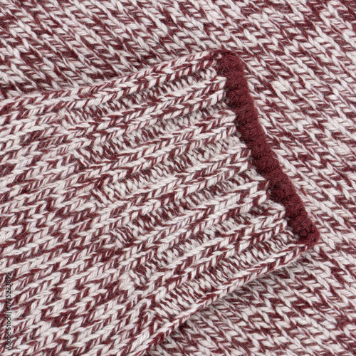 Close-Up of White-Red Melange Wool Sweater Sleeve with Ribbed Cuff and Red Trim