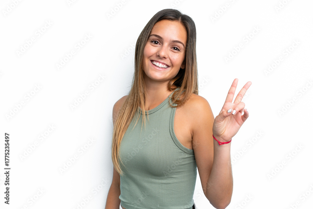 Fototapeta premium Young caucasian woman isolated on white background smiling and showing victory sign
