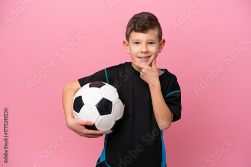 Foto Little caucasian football player boy isolated on pink background thinking