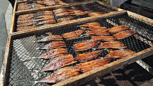 Fotografie Rows of dried fish on a rack under sunlight, Traditional Asian food