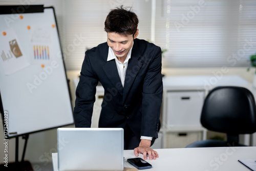A businessman is discussing work with a client at a desk in an office.