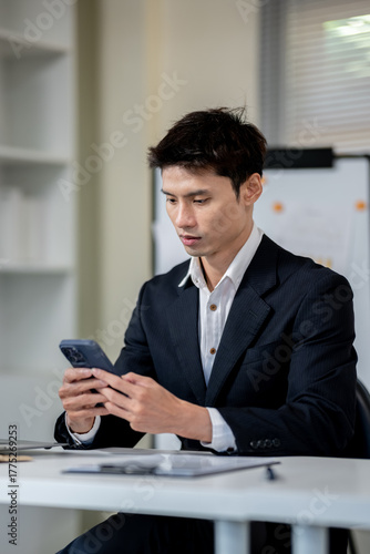 A businessman is discussing work with a client at a desk in an office.