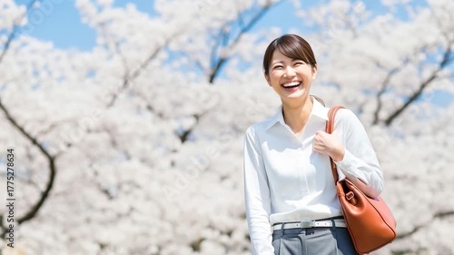 満開の桜の下で笑うビジネスウーマン