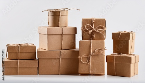 stacked brown cardboard gift boxes with lids and natural string isolated on white backdrop packaging mockup
