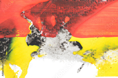 Vibrant thick red black and yellow acrylic paint splashes lines and swirls on a white background