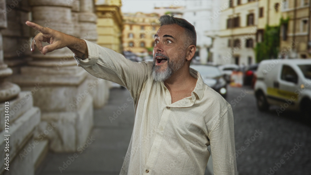Fototapeta premium Man points finger at a passing car on a narrow city street, open linen shirt visible; surprise discovery curiosity.