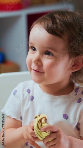 little one crafting with vibrant modeling material, toddler focused on molding soft clay during indoor