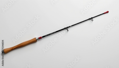 A fishing rod with an accompanying reel, poised against a plain background.