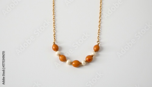 A necklace with an orange stone pendant. The pendant appears to have multiple carvings or engravings, although the details are not clear from this angle