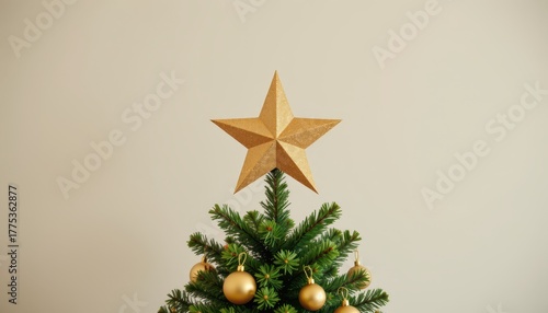 Green pine Christmas tree top decorated with a shimmering gold star topper and shiny gold ornaments