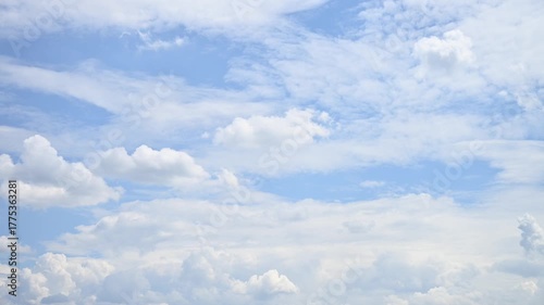 Peaceful time-lapse of soft white clouds drifting across light blue sky in daylight, no people, natural weather background.