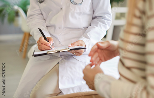 Fotografija Doctor writing in clipboard close up, female patient consulting woman gynaecolog