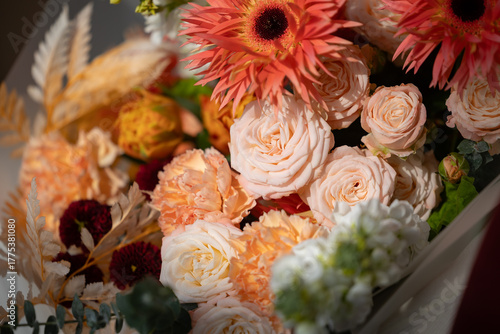 Tableau sur toile Vibrant floral bouquet with roses, gerberas, and sunflowers in warm tones