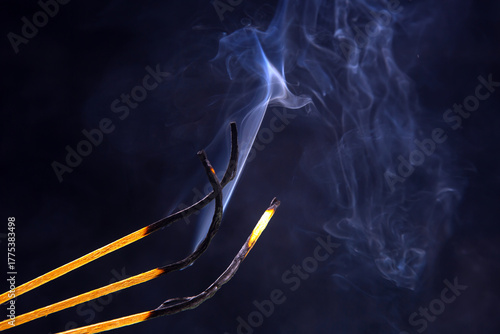 Incense sticks burning and releasing fragrant smoke in a serene setting