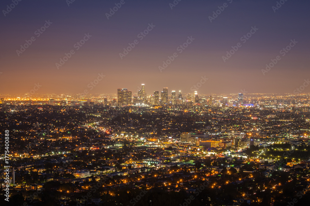 Obraz premium Panoramic night view of Los Angeles city from Griffith Observatory, glowing skyline, urban lights, cityscape under twilight sky, vibrant atmosphere, modern architecture, travel destination, California