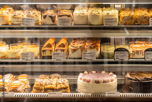 Assorted decorative cakes arranged on tray selling at bakery shop.