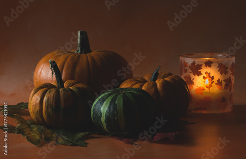 Pumpkins with tea light holder with autumn leafs on it. 