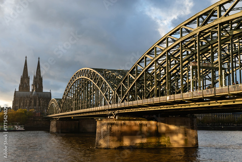 Cologne, Germany - October 26, 2025: Historic landmark of Cologne with the Hohenzollern Bridge in the foreground and the Gothic Cologne Cathedral in the background at sunset