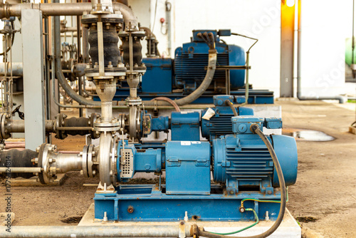 Industrial pumps and metal pipes in a machinery equipment, blue industrial motors.