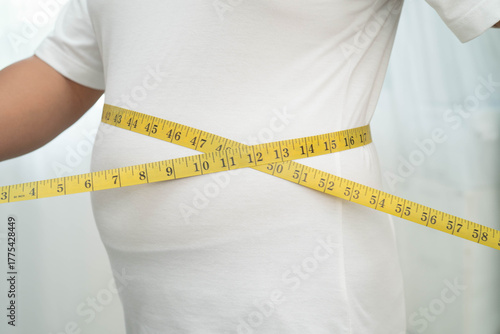 Asian woman with fat belly big size overweight and obesity with measure tape.