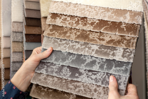 Samples of multicolored fabrics. A woman chooses a fabric for a sofa. Catalog of textiles for the manufacture of upholstered furniture. Color selection. textile industry.