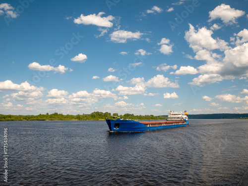 A cargo ship, a cargo ship or an oil tanker, is moving along the river. Logistics and cargo transportation by ship, Freight transportation, river navigation