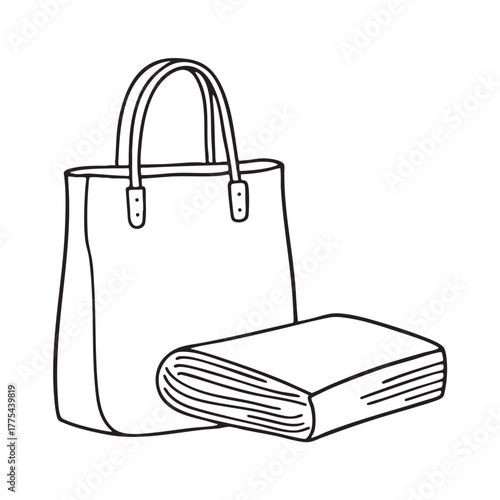 A magazine leaning beside a tote bag with folded edges