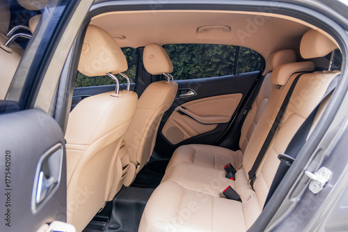 Photograph showing the interior of a modern vehicle from the rear with beige leather seats
