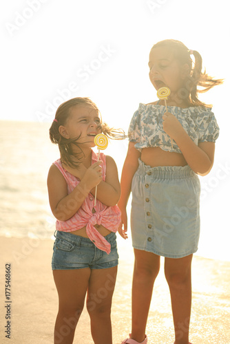 Kids playing outside eating lollipops. Best friends. 