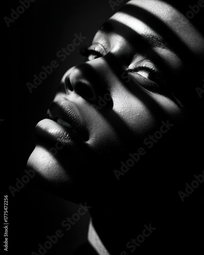 Artistic monochrome portrait featuring bold chiaroscuro lighting technique with geometric shadow patterns on face for dramatic contemporary photography and expressive beauty editorial concepts