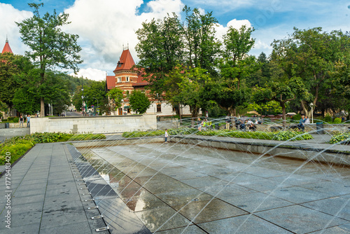 Main square and modern fountain in the Spa Park of Krynica Zdroj, Poland, surrounded by historic resort architecture.