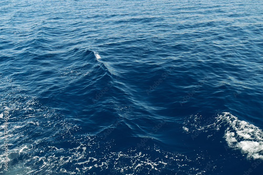Fototapeta premium Tranquil blue ocean waves with sunlight reflection