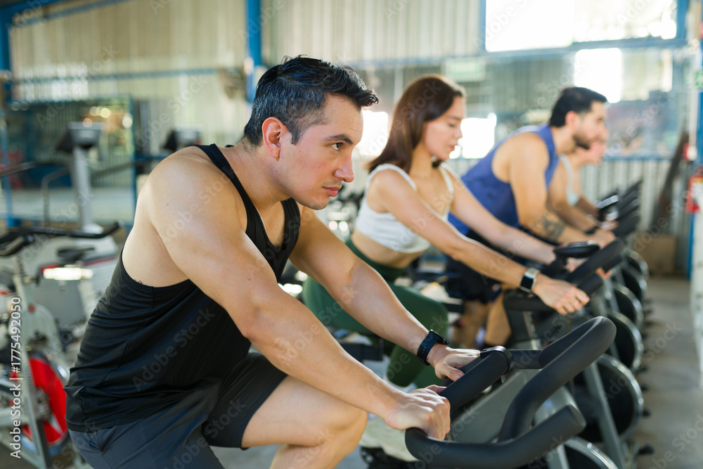 Obraz premium People training on stationary bikes indoor cycling class