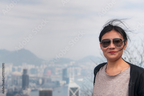a smiling chinese woman on top of victoria peak hong kong