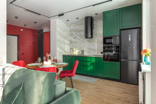 Modern Kitchen and Living Area with Green Cabinets and Red Chairs