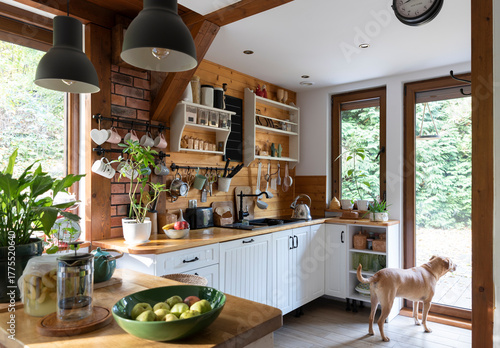 interior of modern kitchen in vintage style with white wooden furniture and rustic detail. Bright indoors with window and wood.