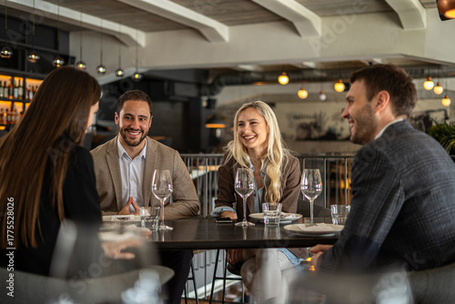 Group of friends enjoying a meal and conversation at a stylish restaurant