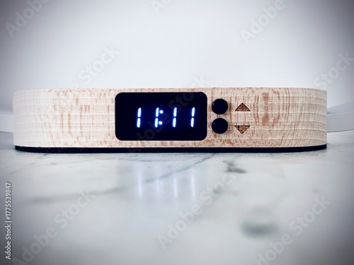 Modern digital wooden clock with LED display on bright background, eleven,