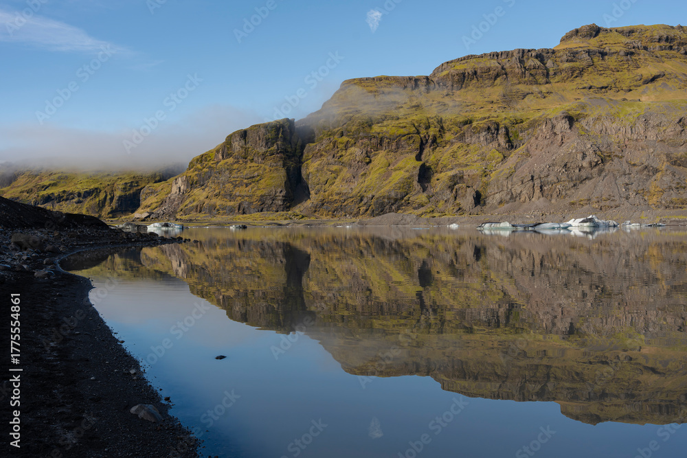 Fototapeta premium Mirror-like lake reflecting the mountains, capturing natural beauty.
