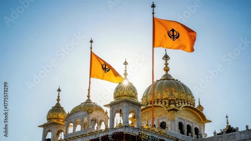 Golden temple with Nishan Sahib flags for Guru Nanak Jayanti celebration. Guru Nanak Jayanti is observed with flags waving above golden domes.