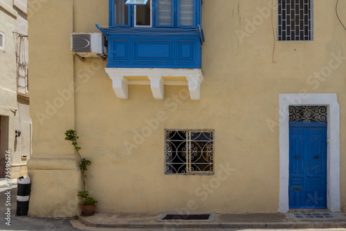 A typical house front in Birgu, Malta - with blue doors and traditional balcony