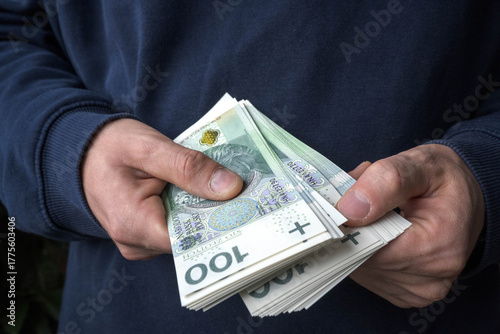 Savings in a man's hand, Polish zlotys.
