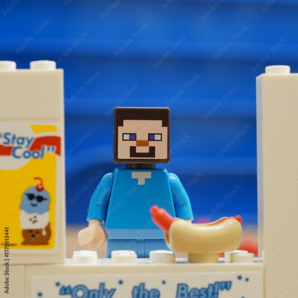 Obraz premium Lego Minecraft Steve minifigure character serves up a fresh hot dog at a custom brick-built food stand