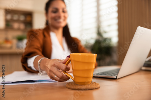 Woman Holding Orange Cup While Working