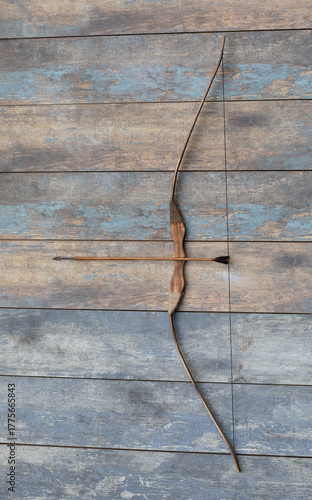ancient wooden bow on a wooden background