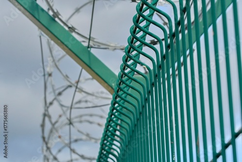 Barbed razor wire on a high-security building. Barbed wire and hard wire fence. Concepts for jails, army facilities, nuclear power plants, and defense against illegal migration.