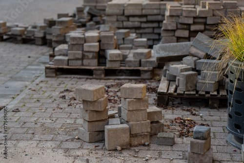 Quadro em tela Stack of concrete paving blocks and construction materials on site showing urban