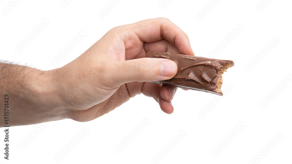 Fototapeta premium Hand holding a bitten chocolate bar against a plain background in a simple and clean setting